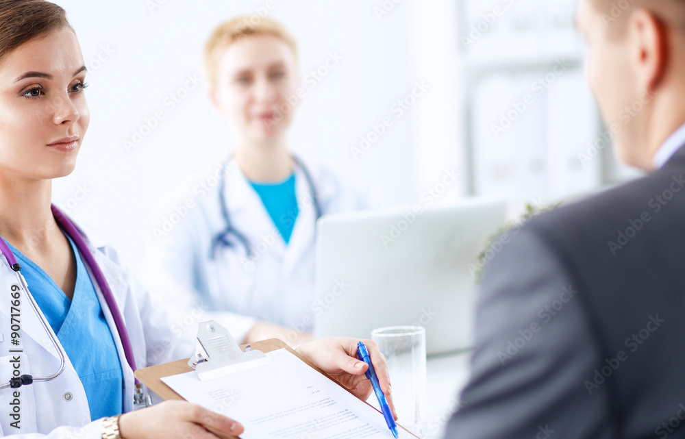 Medical team sitting at the table in modern hospital Medical team sitting at the table in modern hospital
