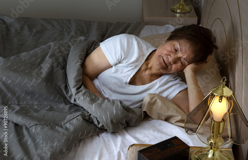 Fotografija Senior woman restless at nighttime while trying to sleep