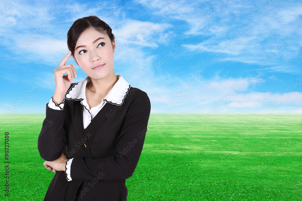 Business woman thinking with green grass field and blue sky Business woman thinking with green grass field and blue sky