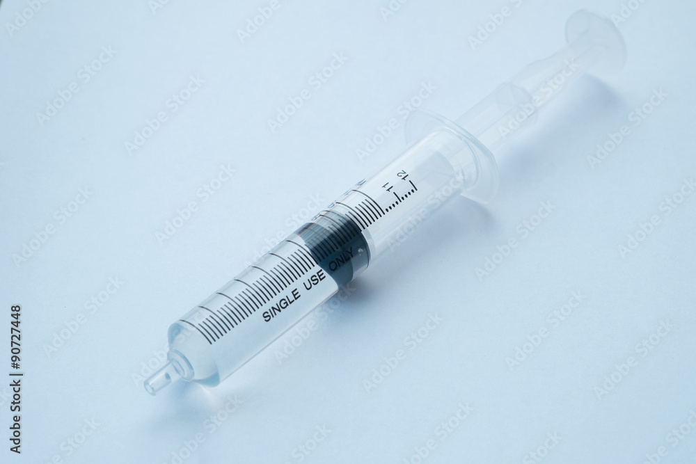 syringe with clear liquid on light background syringe with clear liquid on light background