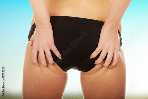 Woman touching her buttocks.