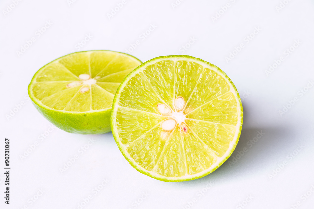 sliced green lime on a white background (half). sliced green lime on a white background (half).