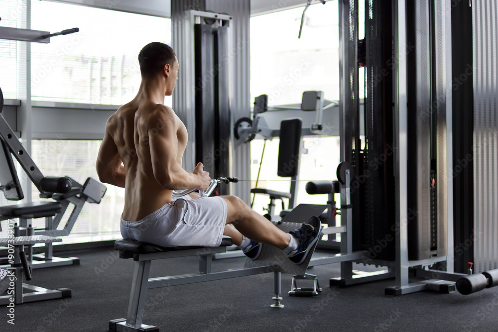 Athletic strong bodybuilder execute exercise in sport gym hall Athletic strong bodybuilder execute exercise in sport gym hall