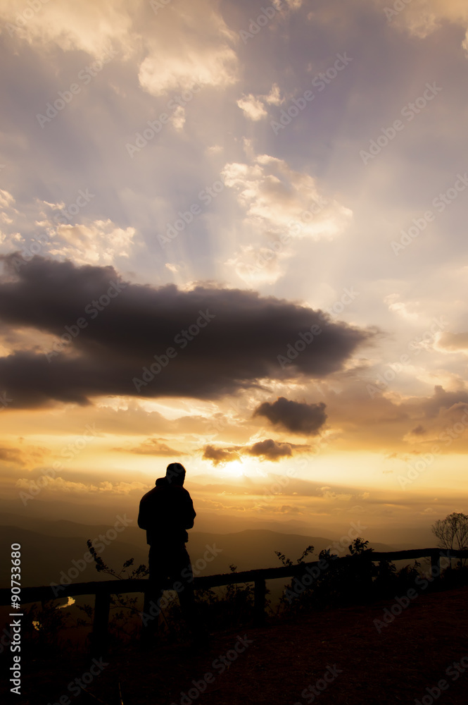 Silhouette of a man waiting for the sunrise at mountian
