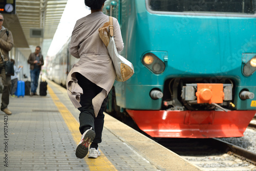 People on railway staition. Running woman miss train. photo