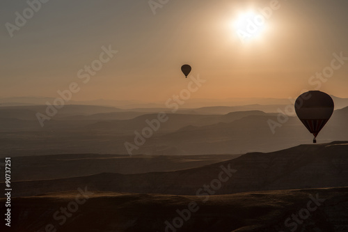 Balloons over mointains and rocks in cappadocia 