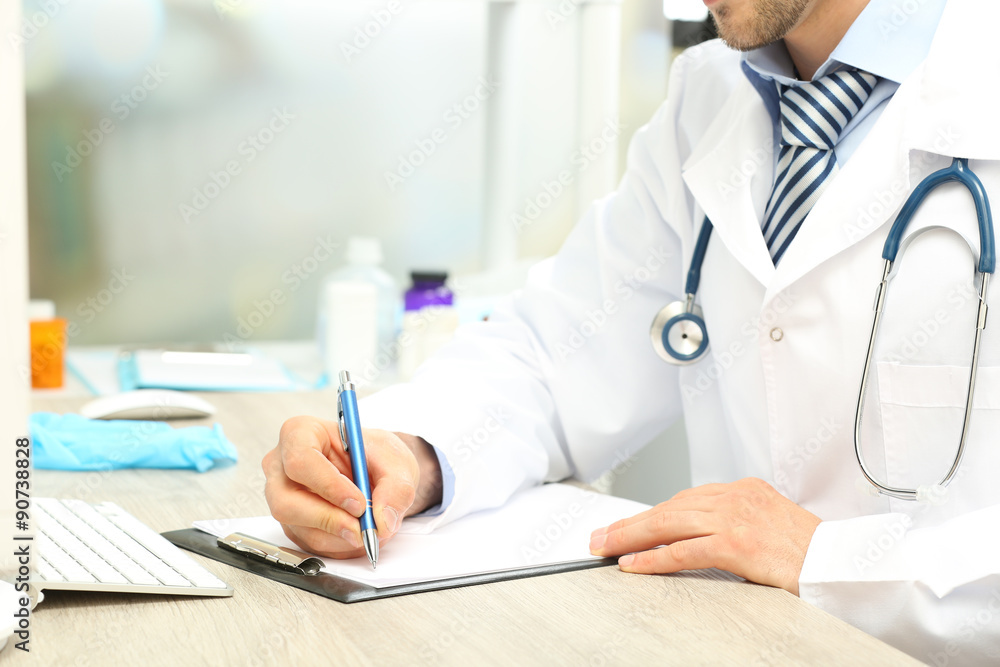 Doctor working at table in office Doctor working at table in office