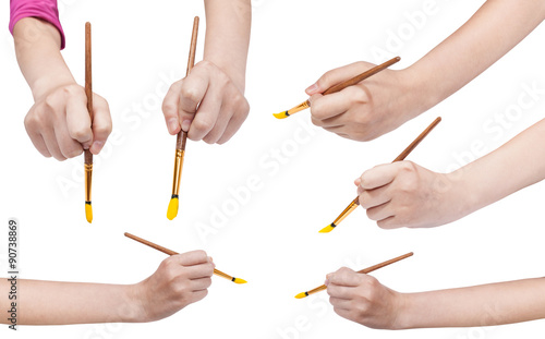 set of hands with art paintbrushes with yellow tip photo