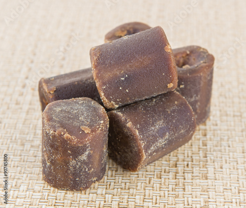 Coconut palm sap sugar or locally know as gula melaka over wicker background 