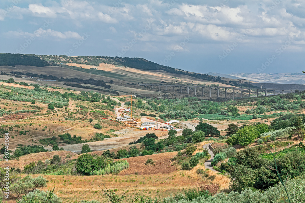 Obraz premium green landscape of valley with a bridge and crane 