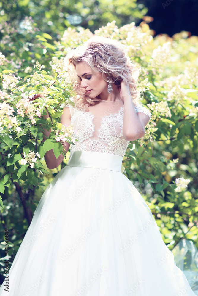 Beautiful bride posing outdoor. Wedding dress, curly blond hair. Beautiful bride posing outdoor. Wedding dress, curly blond hair.