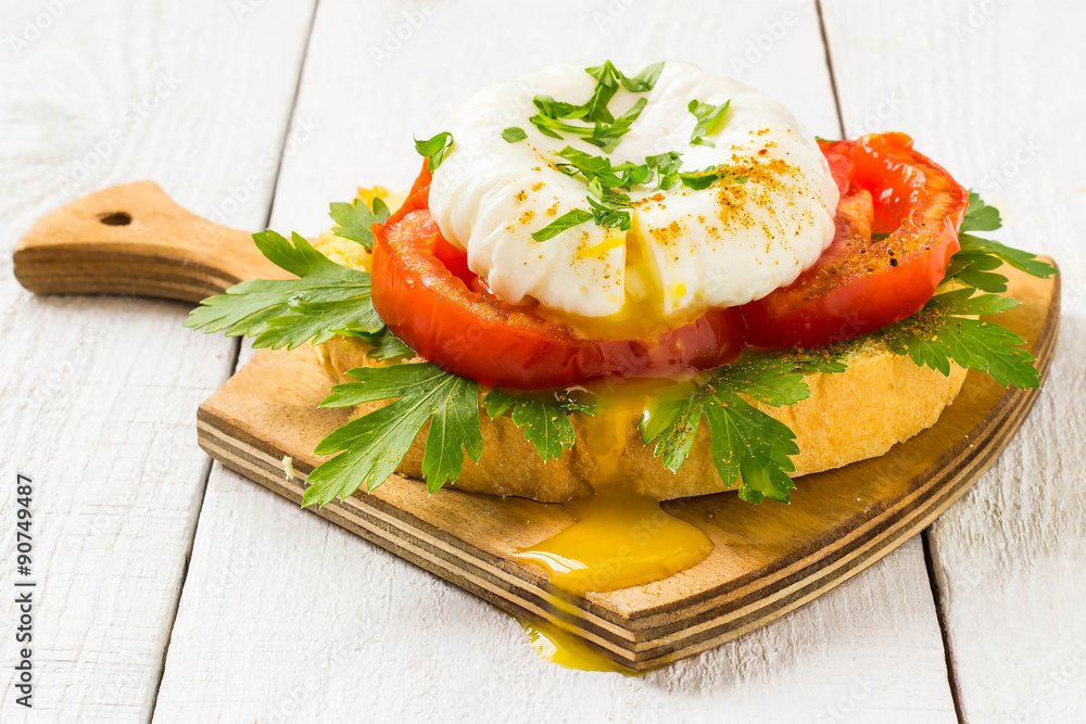 Poached egg on toast with tomatoes and parsley Poached egg on toast with tomatoes and parsley