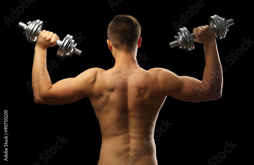 Muscle young man holding du...