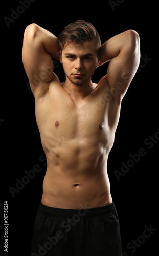 Muscle young man on dark ba...