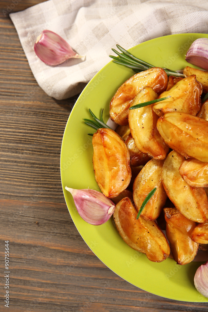 Baked potato wedges on wooden table, top view Baked potato wedges on wooden table, top view