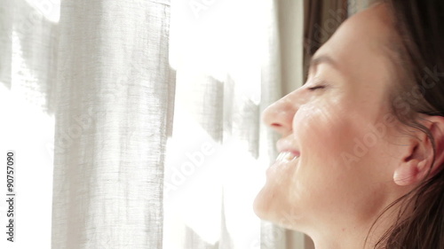 Girl opens the curtains in the morning, close up