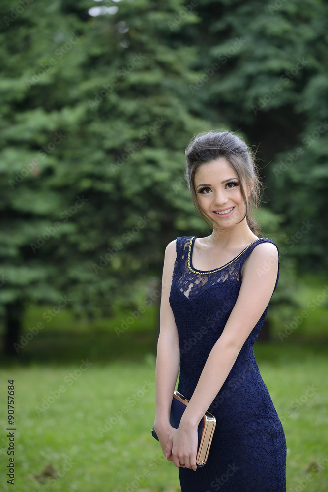 Beautiful formally dressed young woman smiling outside in park Beautiful formally dressed young woman smiling outside in park