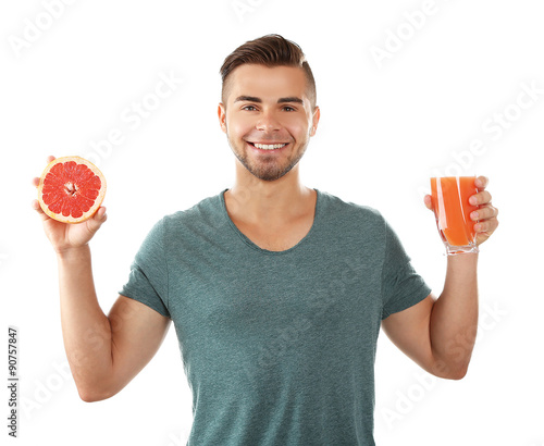 Young man showing glass of grapefruit juice, isolated on white