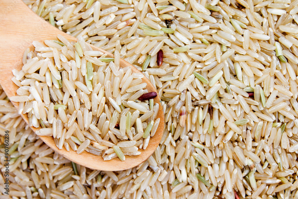 food background. brown rice in a wooden spoon. top view