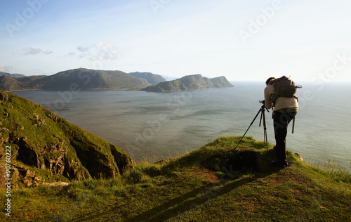 Camera woman filming outdoors on the coast of Norway. 
