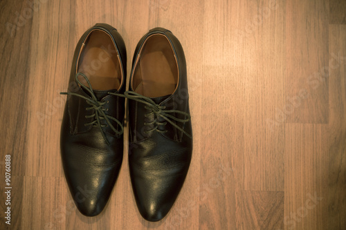 A pair of brown leather shoes on wooden floor - vintage style effect picture