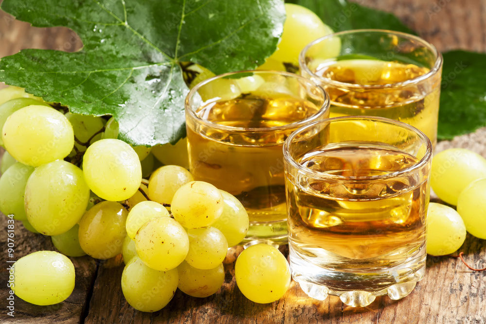 Light grape juice on wooden background, selective focus Light grape juice on wooden background, selective focus