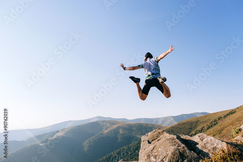 man jumps from the cliff in mountains