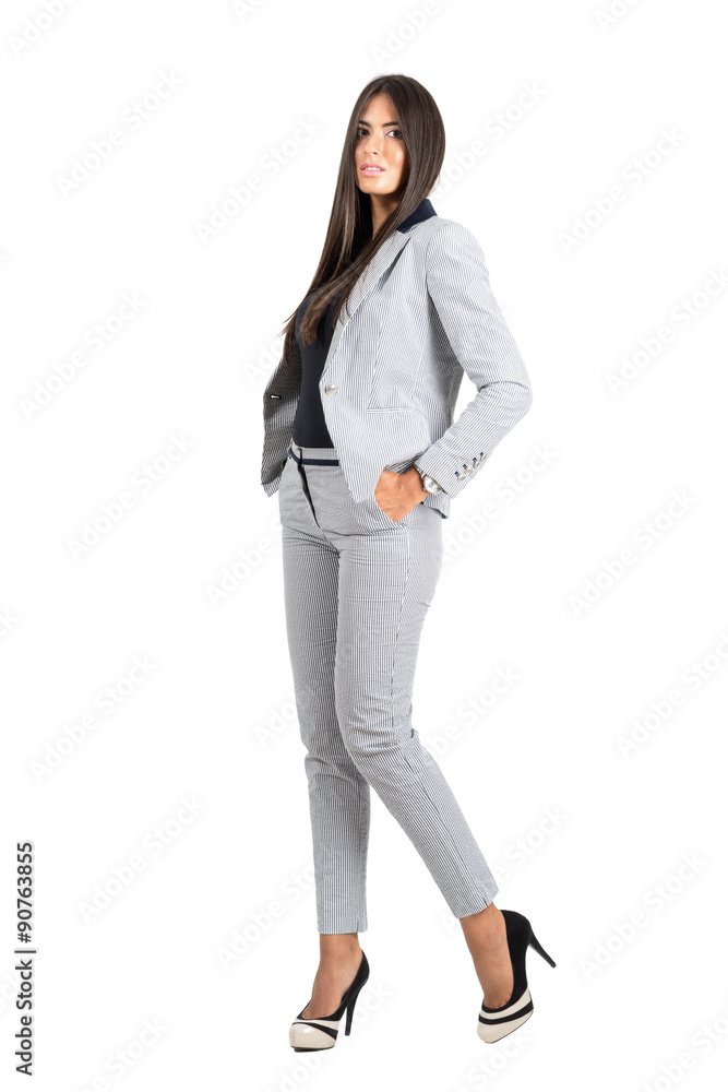Young business woman with hands in pocket in elegant business stripped suit. Young business woman with hands in pocket in elegant business stripped suit.