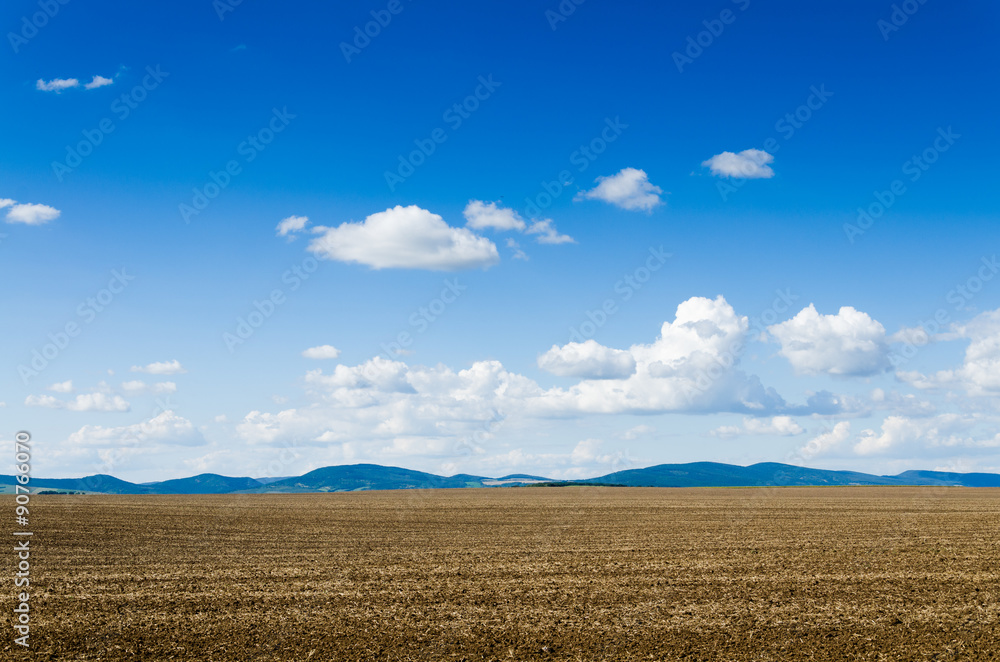 Arable land over dramatic blue sky