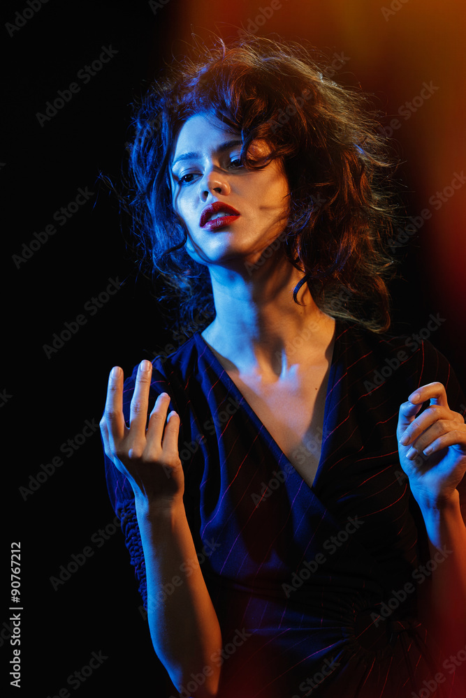 Fototapeta premium beautiful brunette in the glow of blue and red light
