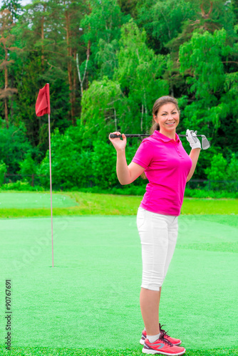 young beautiful girl on a golf course with a golf club