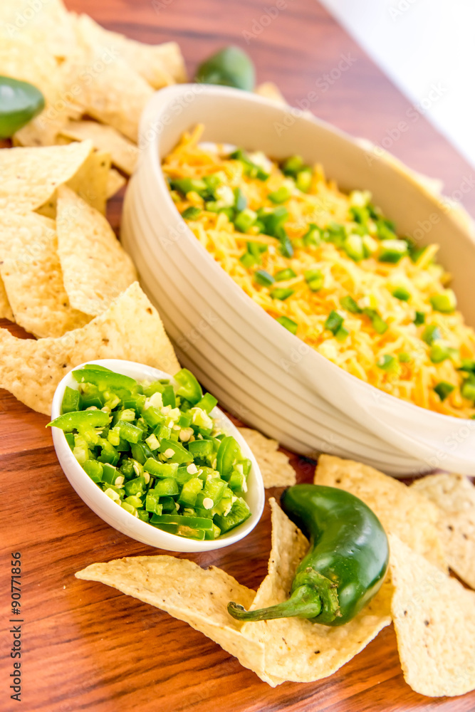 preparation of bean dip with jalapenos, sour cream and cheddar c preparation of bean dip with jalapenos, sour cream and cheddar c