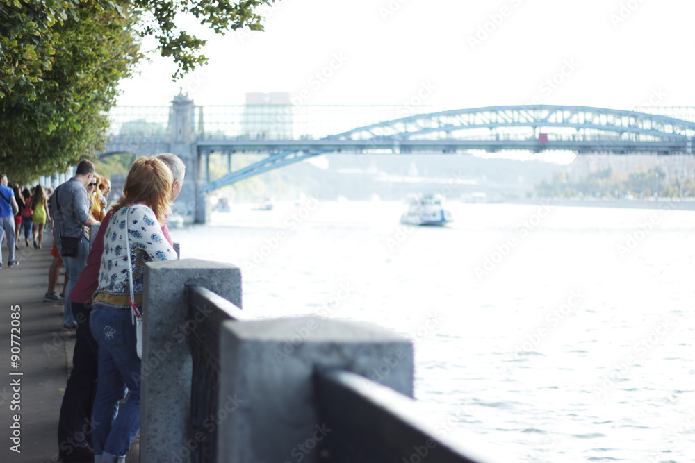 Couple looking to the bridge across the river Couple looking to the bridge across the river