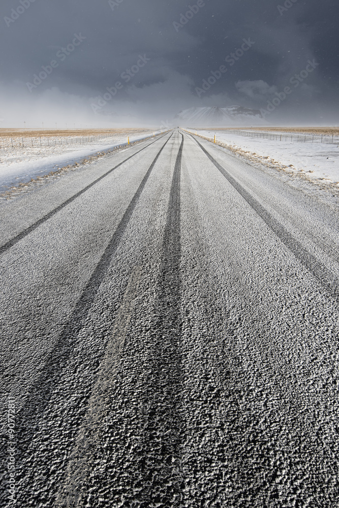 Strada innevata con tracce di pneumatici verticale