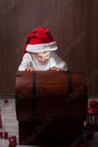 Two adorable boys, opening wooden chest, glowing light from insi photo