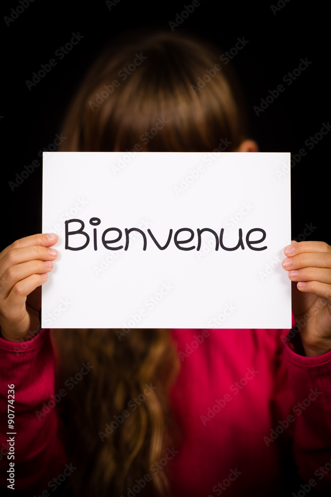 Child holding sign with French word Bienvenue - Welcome Child holding sign with French word Bienvenue - Welcome