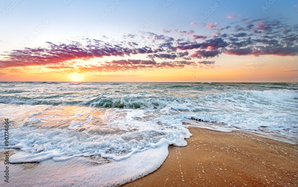 Obraz premium Wschód słońca kolorowe plaży oceanu z głębokim błękitnym niebem i promieniami słońca.