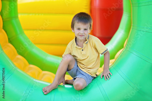 Cute little boy, playing in a rolling plastic cylinder ring, ful