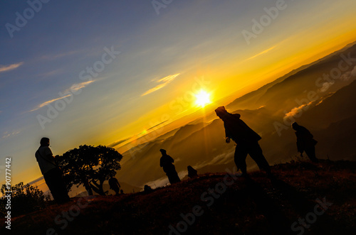 Silhouette hikers see sunset on top of a mountain
