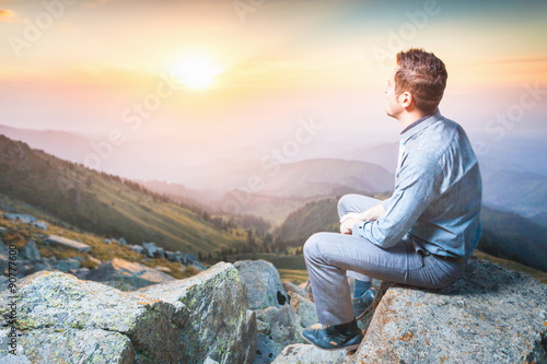 businessman at the top of the mountain sitting and thinking