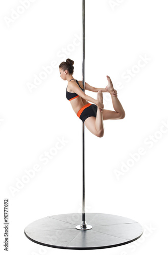 Pretty gymnast warming up on pylon. Studio photo 