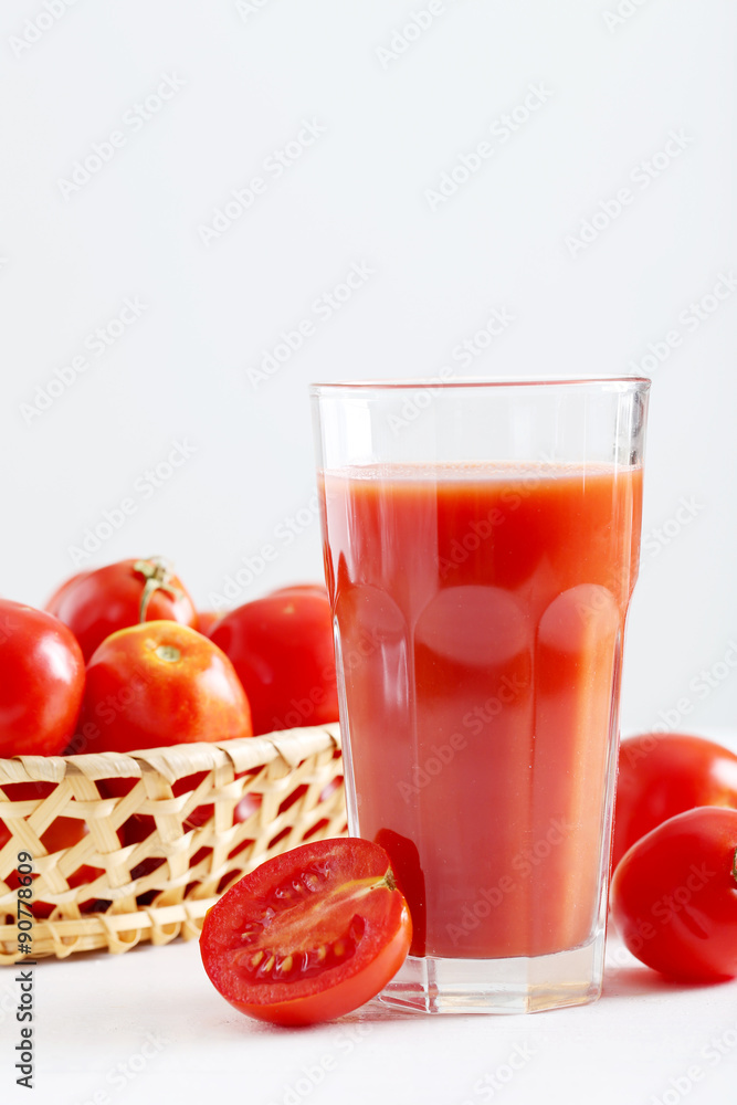 Fresh red tomatoes and tomato juice in glass on wooden table Fresh red tomatoes and tomato juice in glass on wooden table