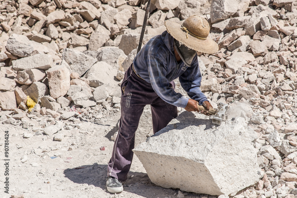 Worker in a stone quarry working on lime stone or marble Worker in a stone quarry working on lime stone or marble