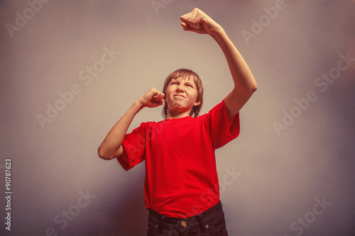 Boy, teenager, twelve years red in shirt, showing fists his 