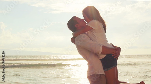 Honeymoon passionate couple holding each other. romantic in love kissing at beach sunset. Newlywed happy young couple enjoying ocean sunset during travel holidays vacation getaway. 