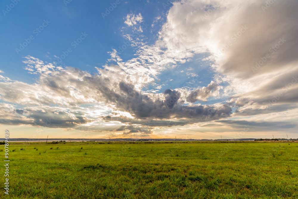 Dramatic sunset over green field 