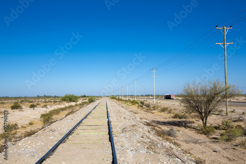 Straight train rails in the north of Argentina with blue sky © piccaya