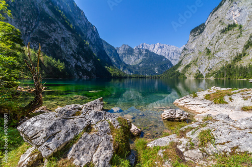 Beautiful landscape of alpine lake with crystal clear green water and mountains in background, Obersee, Germany