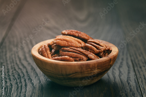 pecan nuts in olive wood bowl on oak table
