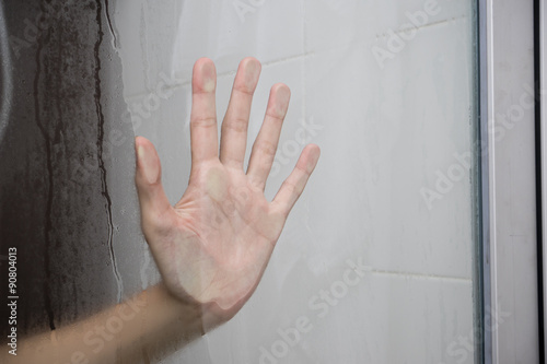 Woman hand behind glass 1